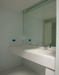 Waschtischbereich mit fliesenbündigen Spiegel und verdeckter Beleuchtung